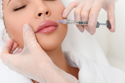 Professional cosmetologist making facial injection